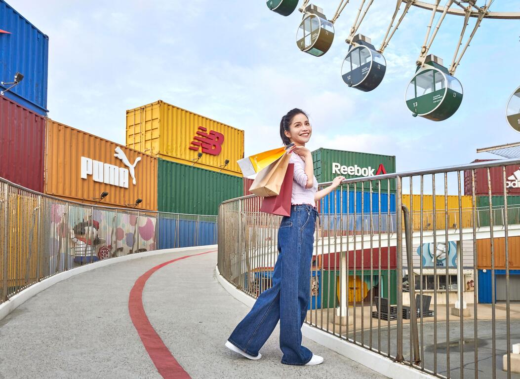 台中港三井 Outlet 戶外購物區,彩色貨櫃店鋪、摩天輪與手提購物袋的旅人,展現海線購物休閒氛圍。