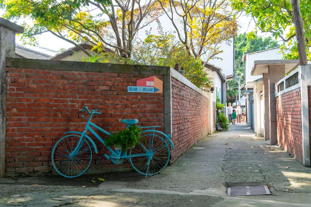台中清水眷村文化園區巷弄景色,紅磚牆旁擺放藍色自行車,展現懷舊眷村氛圍。