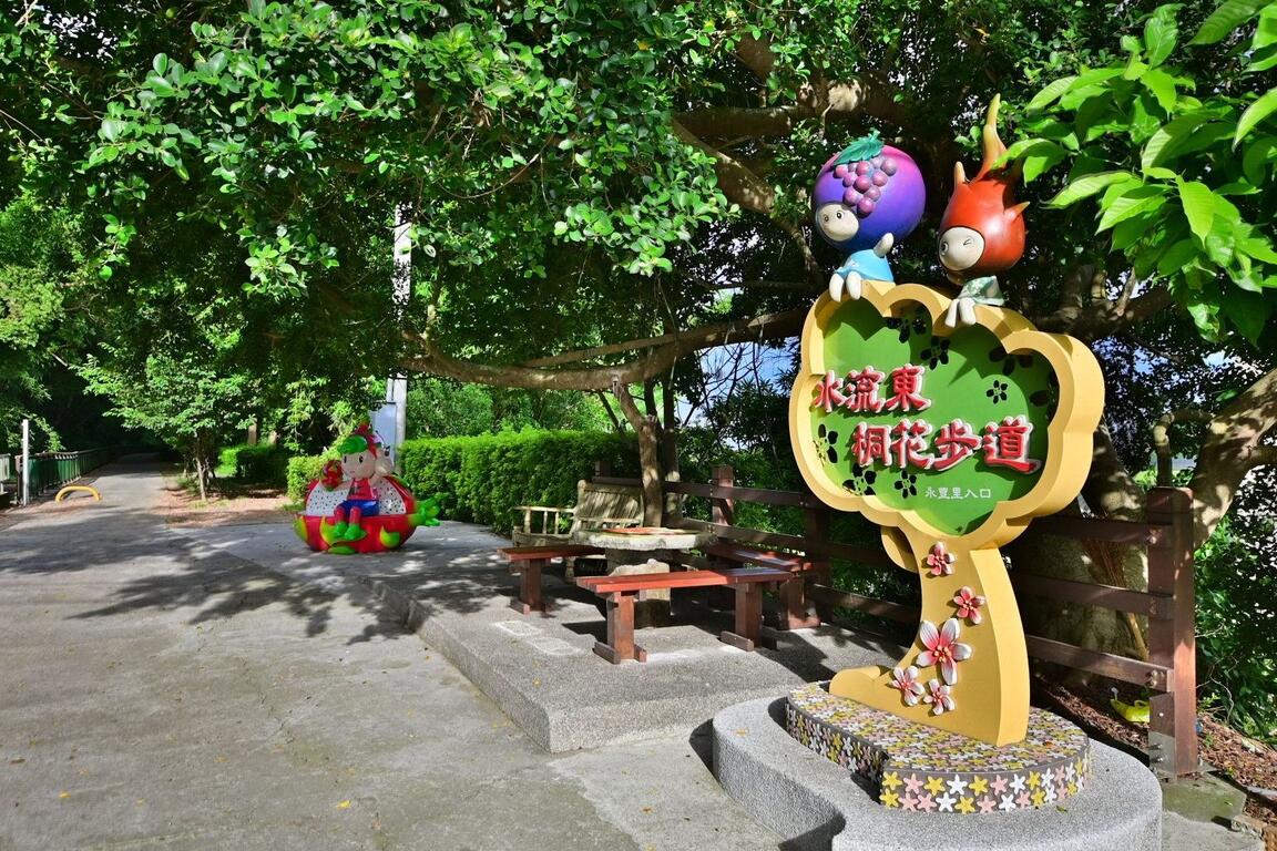 台中水流東桐花步道入口，綠蔭步道旁設有彩色地標與休憩座椅，適合散步賞花。