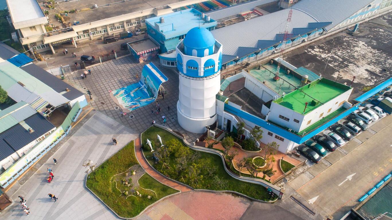 台中大安濱海樂園與向海那漾露營區空拍景色，可見海灘、海岸線、風力發電機與園區設施。